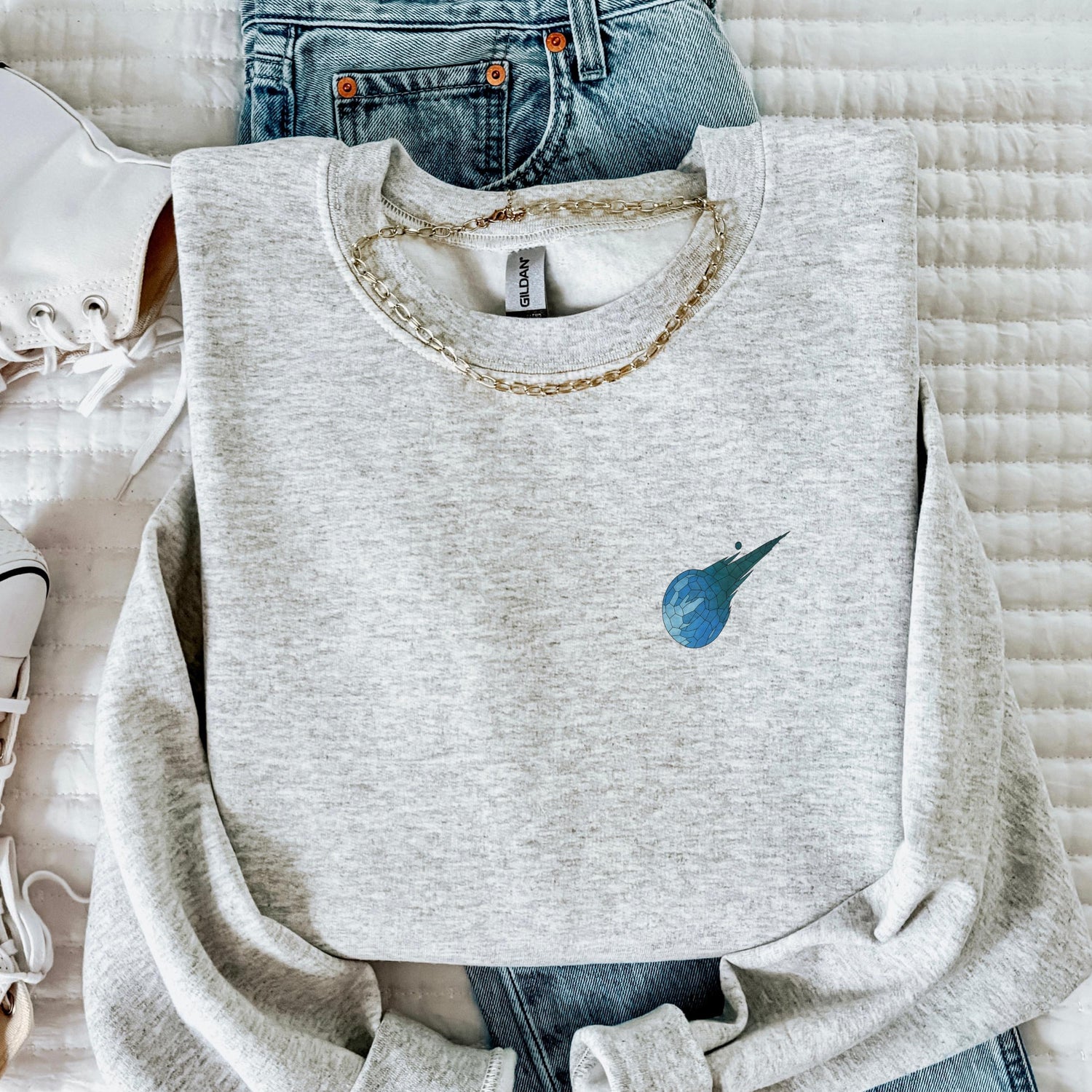 Gray sweatshirt with a blue logo on a white surface