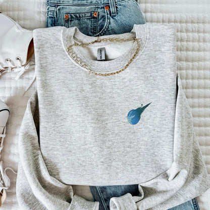 Gray sweatshirt with a blue logo on a white surface